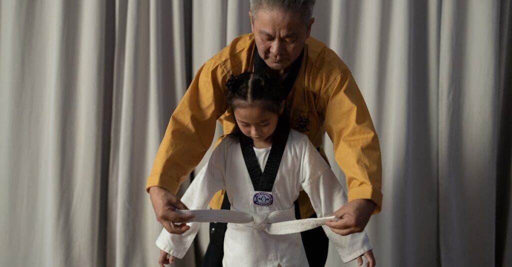 Instructor helping student during taekwondo for teenagers belt training